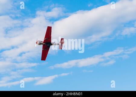 Light aircraft flying in blue sky and doing stunts Stock Photo