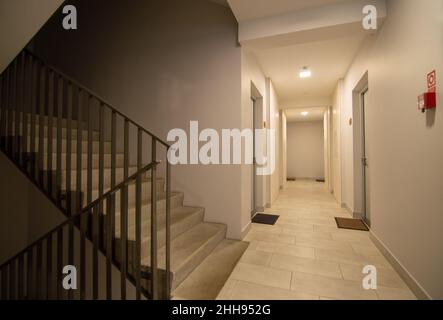 Hallway and staircase in an apartment building with entrance doors to flats Stock Photo
