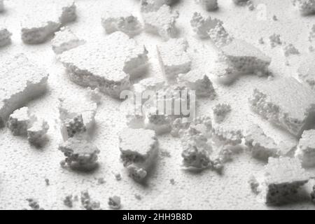 Broken pieces of white styrofoam on the sheet of white styrofoam Stock Photo