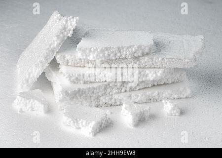 Stack of broken pieces of white styrofoam on the sheet of white styrofoam Stock Photo