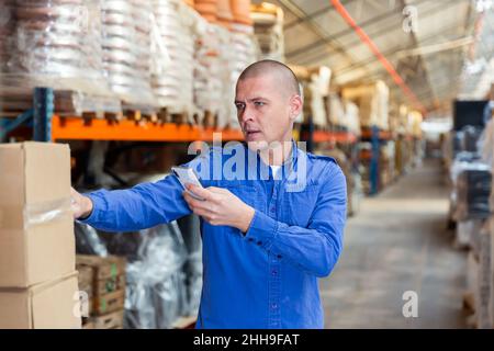 Fulfillment center worker using smartphone in his work Stock Photo