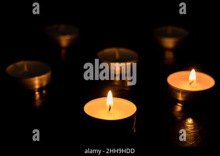 Two candles Burning out of six on dark table, black background, Memory day. Stock Photo