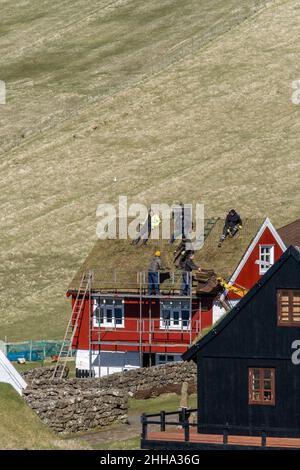 The roofers taking a rest on top of the roof of a house in Faroe Islands. Stock Photo
