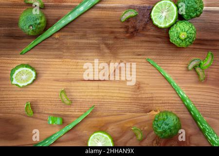 Aloe, kaffir lime and bergamot on wooden surface background Stock Photo