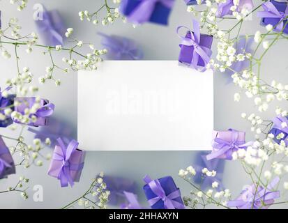 A multi-layered postcard made of gift boxes in a fashionable, trendy very peri color with white flowers on a foggy background. Happy women day and Val Stock Photo