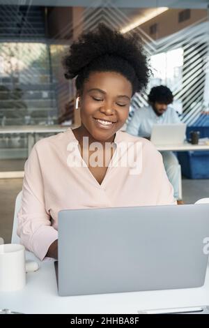 Smiling african american businesswoman working on laptop online portrait