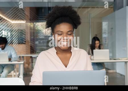 Young female student or worker using laptop to read news, watching webinar Stock Photo