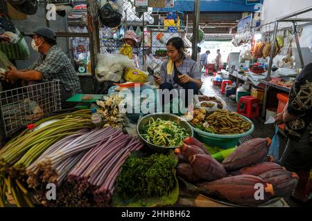 Phnom Penh, Cambodia - January 2022: A woman selling vegetables at a stall in the Central Market on January 22, 2022 in Phnom Penh, Cambodia. Stock Photo