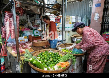 Phnom Penh, Cambodia - January 2022: A woman selling raw meat and vegetables at a Kandal market stall on January 22, 2022 in Phnom Penh, Cambodia. Stock Photo