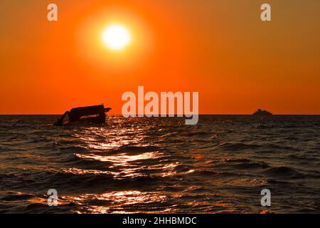 Sunset over SS Atlantus Shipwreck and Ferry in Background, Cape May, New Jersey Stock Photo