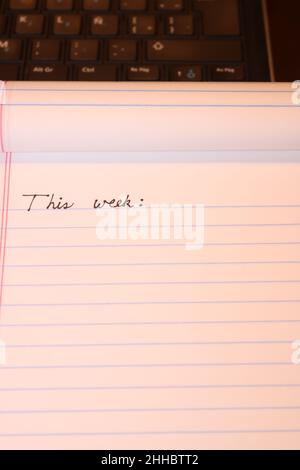 'This week', text written on notebook. Time management concept.  Planning ahead with a To-do list. Stock Photo