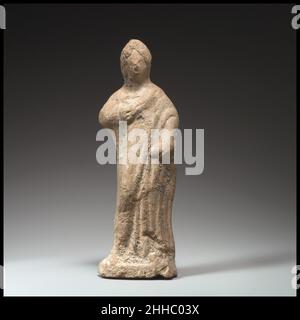 Terracotta statuette of a woman standing 4th–3rd century B.C. Greek Standing, draped statue of a woman.. Terracotta statuette of a woman standing  244801 Stock Photo