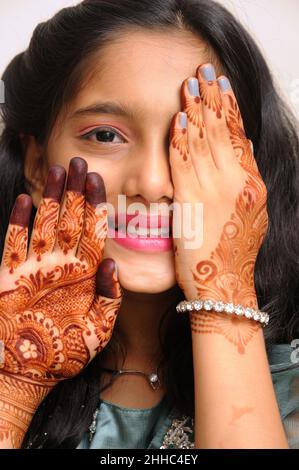 Mumbai - July 20 2021 Beautiful young indian teenager girl showing artwork of Henna Mehndi Henna dye is applied on girl's hand during Indian festival. Stock Photo