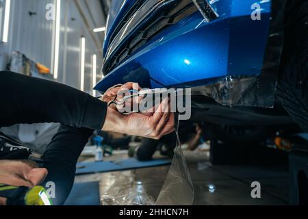 Car detailing. Man applies nano protective coating to the car in car detailing service Stock Photo