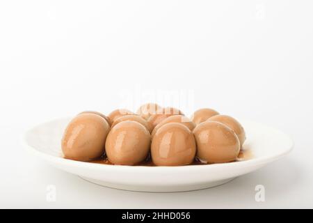 Stewed quail eggs on a white background Stock Photo