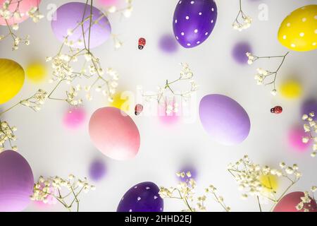 Easter eggs of delicate colors, pink, purple, yellow with white flowers on a transparent foggy background. Bright Easter Holiday Stock Photo