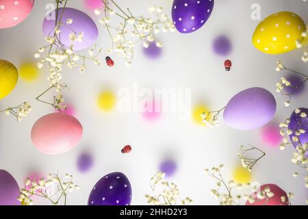 Easter eggs of delicate colors, pink, purple, yellow with white flowers on a transparent foggy background. Bright Easter Holiday Stock Photo