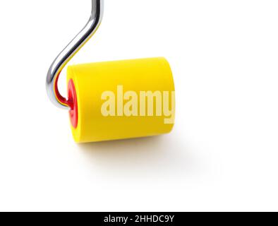 Yellow rubber paint roller on a white background. Stock Photo