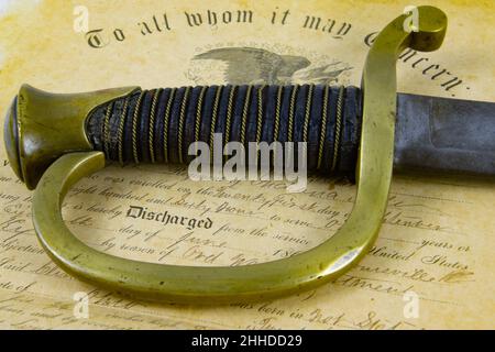Old Sabre lying on a historic document of Union Army discharge Certificate from 1863 with focus on Handle Stock Photo