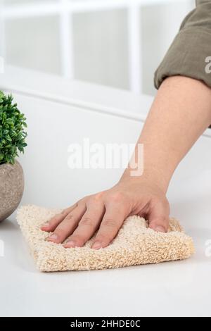 Woman housewife is doing the spring cleaning at home kitchen with using rag, spraying bottle cleaner to wipe the counter table surface. Stock Photo