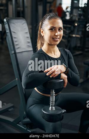 Joyous female athlete posing for camera during gym workout Stock Photo