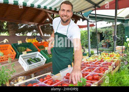 farmer sells fruit and vegetables from his own cultivation fresh from the field and from the greenhouse Stock Photo