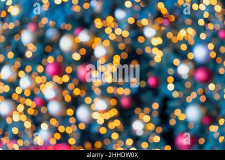 Christmas tree light and bauble colorful festive bokeh background. Holiday blur decoration Stock Photo