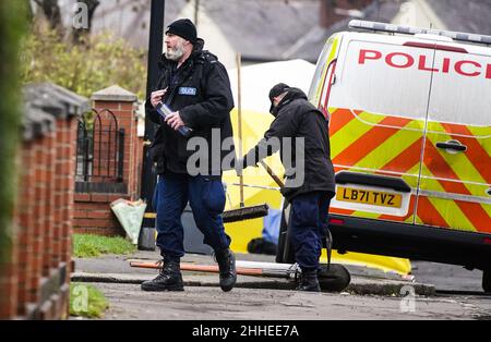 Greater Manchester Police officers searching for evidence at the scene have a knife in a plastic tube, on Thirlmere Avenue in Stretford, Manchester, after a 16-year-old boy, named by police as Kennie Carter, was fatally stabbed at around 7pm on Saturday. Picture date: Monday January 24, 2022. Stock Photo