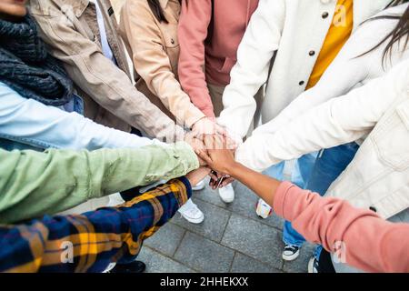 Young people stacking hands in city street Stock Photo