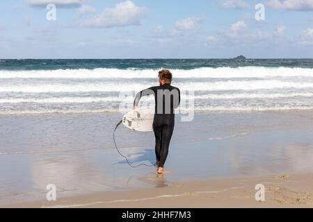 Surfer, surfer and surfboard, surfboard, Hayle beach, Cornwall, UK, England, Cornwall surfer, Cornwall surfboarding, surfboarder, surf boarder, sea Stock Photo