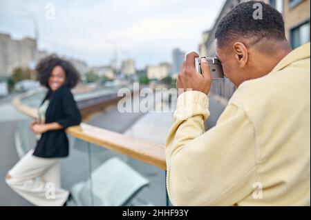 Man with his back to camera photographing woman Stock Photo