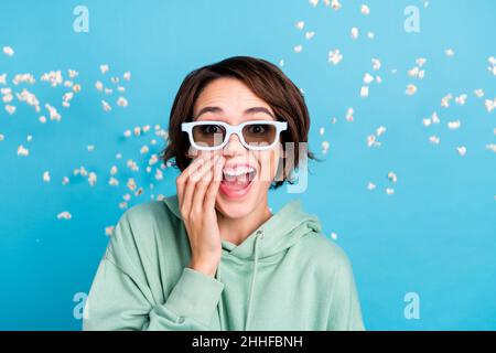 Photo of excited charming woman wear green sweatshirt sunglass flying popcorn laughing isolated blue color background Stock Photo