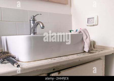 White sink on wood counter with a mirror hanging above it. Bathroom interior. Stock Photo