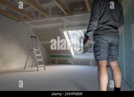 Man plastering drywall in a private house. Stock Photo