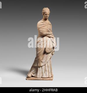 Terracotta statuette of a draped woman 3rd century B.C. Greek, Attic The lady holds a fan in her left hand.. Terracotta statuette of a draped woman  248167 Stock Photo