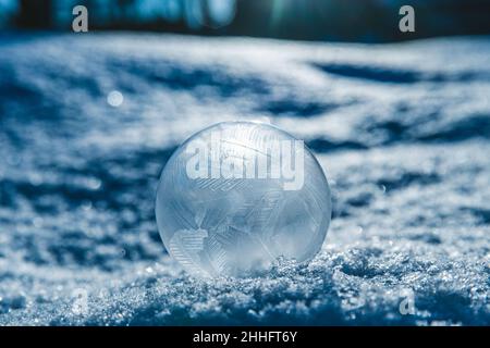 frozen soap bubble in winter on snow. magic nature Stock Photo