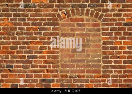 A flat on area of antique red brick wall with a filled in window Stock Photo