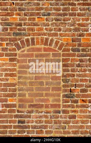 A flat on area of antique red brick wall with a filled in window Stock Photo