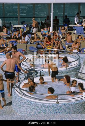 passengers on the swimming pool sun deck of a cruise ship Stock Photo