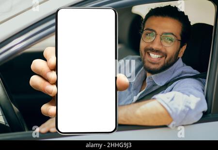 Happy indian driver using showing smartphone with empty screen Stock Photo