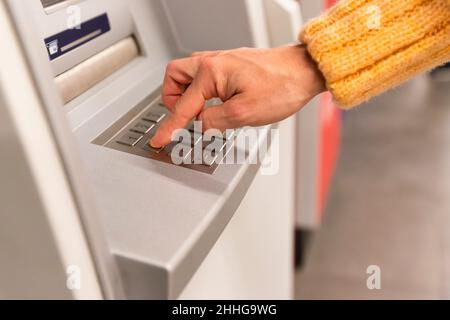 Close up of a womans hand entering secret code on the keypad of an ATM machine Stock Photo