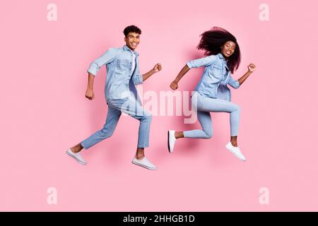 Full length body size view of beautiful cheerful friends friendship jumping running isolated on pink pastel color background Stock Photo