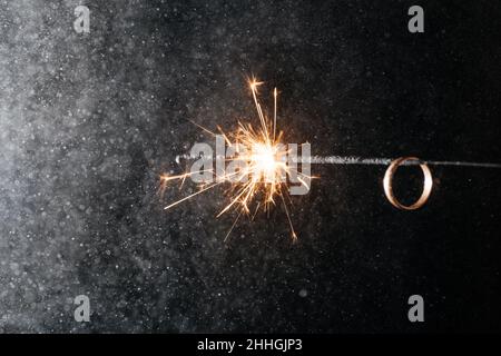 Gold rings with sparklers on a black background.  Stock Photo