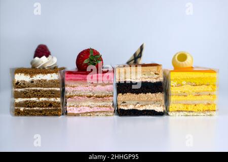 Colorful selection of layered cake slices on a white background Stock Photo