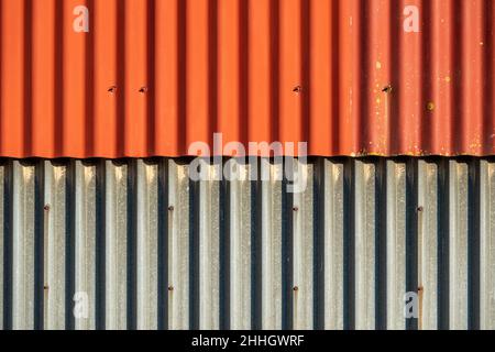 Overlapping two colour corrugated iron panels in wall of farm building Stock Photo