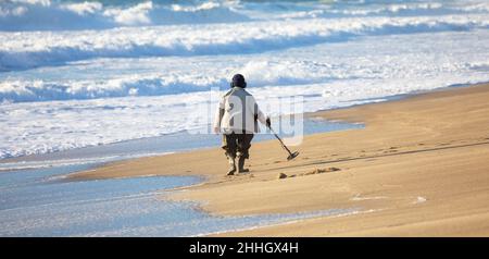 Man with metal detector on the beach Stock Photo