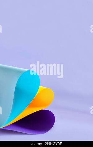 Blue, yellow and violet colorful paper swirl on lilac background Stock Photo