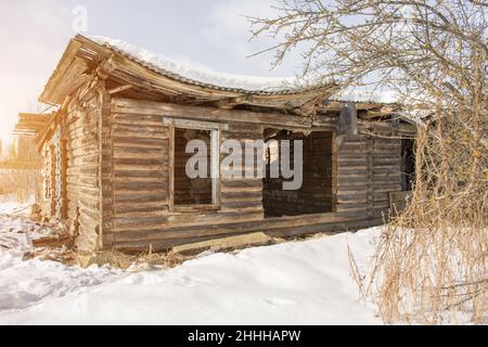 Old ruined wooden house without windows and doors, ruined roof Stock Photo