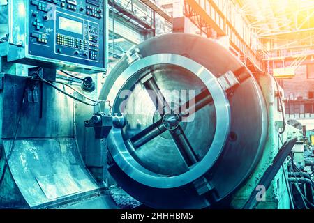 Automated CNC lathe machine tool in metalwork workshop. Modern industrial steel products production and manufacturing. Stock Photo