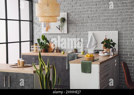 Interior of kitchen with modern furniture and pegboards on grey brick wall Stock Photo
